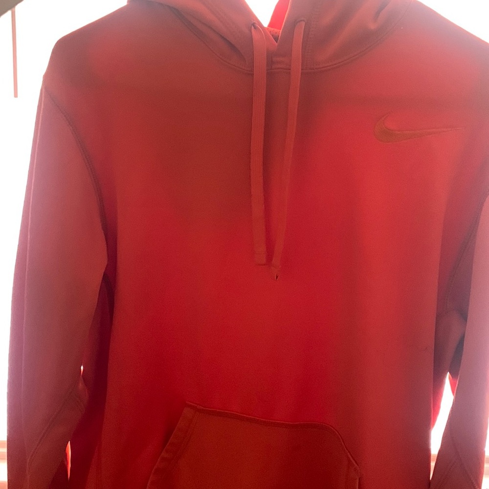 this is a bright orange pullover nike jacket. it is a size small.